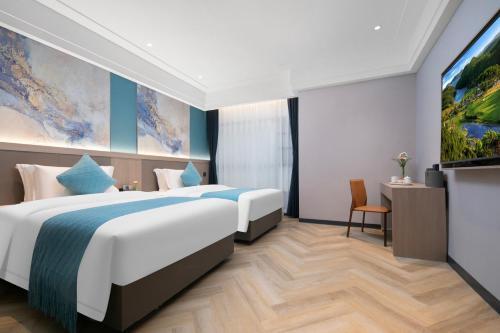 a hotel room with two beds and a flat screen tv at Ramada by Wyndham Wuhan Wangjiawan in Wuhan