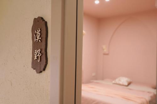 a room with a bed and a sign on the wall at Shantou Qijian Homestay in Changxiacun