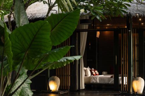 a room with a bed and some plants and lights at Sanctuary Kanchanaburi in Ban Ai Hit