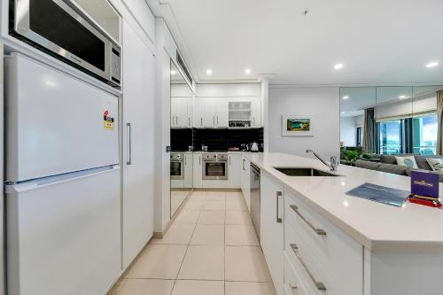 a kitchen with white cabinets and a counter top at Luxurious & Spacious Living with Breathtaking Views in Auckland
