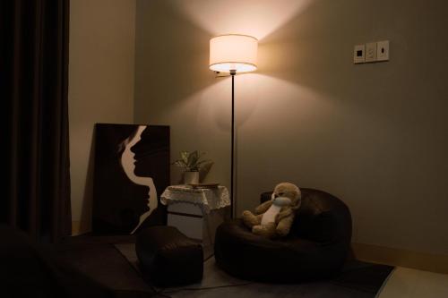 a teddy bear sitting in a chair next to a lamp at InHue Homestay in Thôn Trường Giang