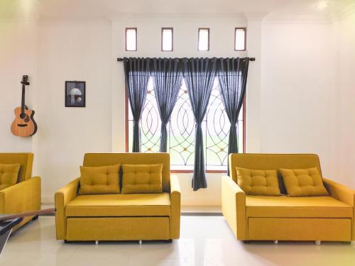 a waiting room with two chairs and a window at Palma Family Hall Klaten in Kuwoso