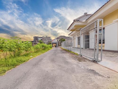 an empty road with a fence on the side of a house at Palma Family Hall Klaten in Kuwoso