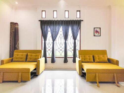a waiting room with two chairs and a window at Palma Family Hall Klaten in Kuwoso