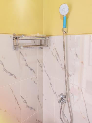 a shower with a shower head in a bathroom at Palma Family Hall Klaten in Kuwoso