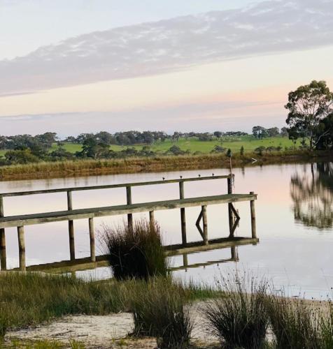 a wooden bridge over a body of water at Askara Lake House in Willunga