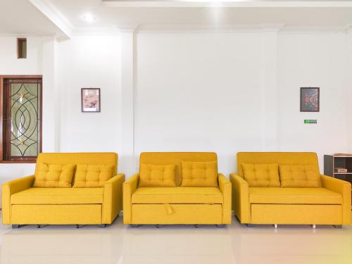 two yellow couches sitting in a room at Palma Family Hall Klaten in Kuwoso