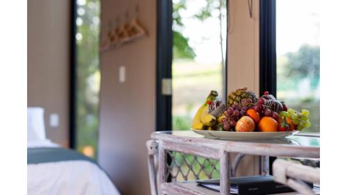 a bowl of fruit on a table next to a window at Forest Hill Farm by Tiny Away in Herbert