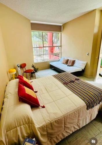 a bedroom with a large bed and a window at Casa Artemisa hostal in Guadalajara