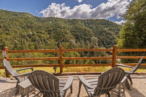 two chairs and a table on a patio with a mountain at Rivertop Hideaway with HUGE views-Hot Tub-EV-more! in Ahwahnee