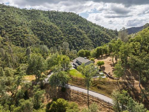 an aerial view of a house in the middle of a forest at Rivertop Hideaway with HUGE views-Hot Tub-EV-more! in Ahwahnee