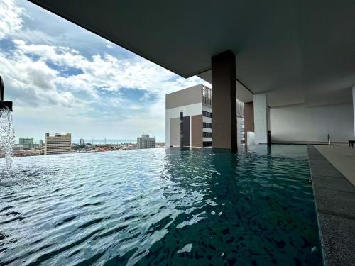 a swimming pool on top of a building with water at Premier condo The Apple in melaka raya in Melaka