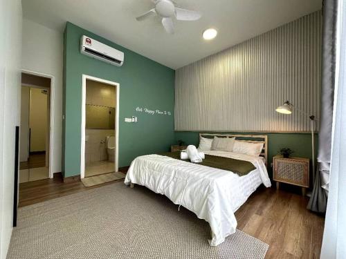 a bedroom with a large bed and a green wall at Premier condo The Apple in melaka raya in Melaka