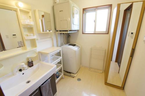 a bathroom with a sink and a washing machine at Maeda Vacation Style in Onna