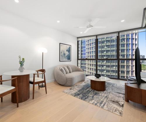 a living room with a couch and a tv at Queen's Wharf Residences Official in Brisbane