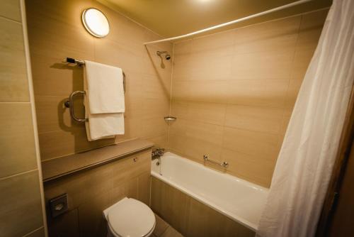 a bathroom with a tub and a toilet and a sink at Roganstown Hotel & Country Club in Swords