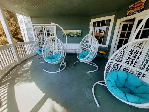 a porch with three white chairs on a house at Enchanting Chateau By The Beach - STR15-0330 in Dana Point