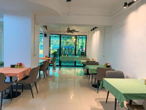 a restaurant with tables and chairs and a stained glass window at Apollo Vientiane Hotel in Vientiane
