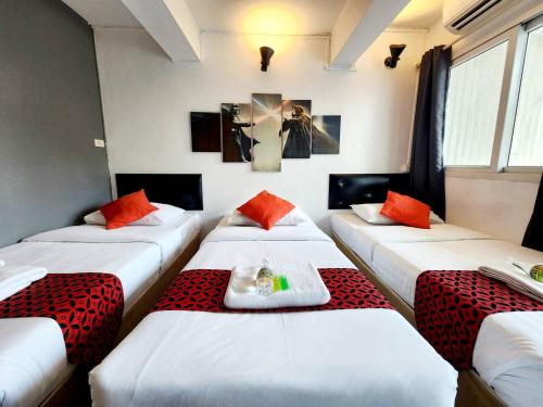 three beds in a room with red and white at Khaosan Art Hotel in Bangkok