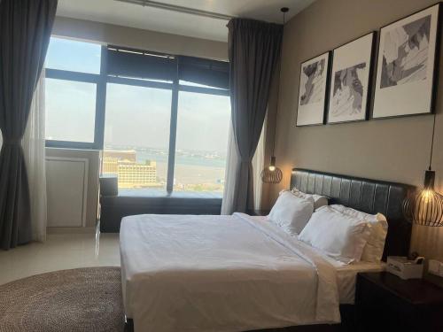 a bedroom with a large bed and a large window at City View Studio in Phnom Penh