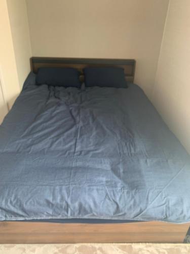 a bed with a blue blanket on top of it at Li Tokyo otta in Tokyo
