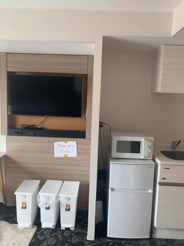 a small kitchen with a microwave and a refrigerator at Li Tokyo otta in Tokyo