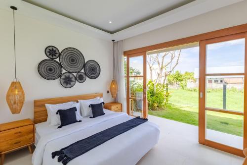 a bedroom with a large bed and a large window at Villa Maria-2BR Private Villa in Canggu in Kerobokan