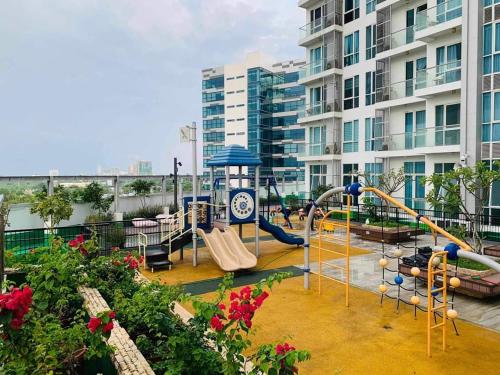 Un parque infantil frente a un edificio con un tobogán. en Mactan Newtown Beach Condo, en Lapu Lapu City