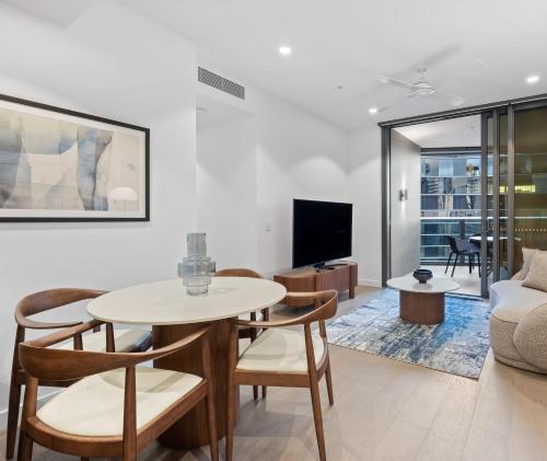 a living room with a table and chairs and a couch at Queen's Wharf Residences Official in Brisbane