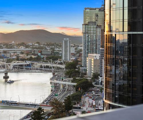 a view of a city with a river and buildings at Queen's Wharf Residences Official in Brisbane