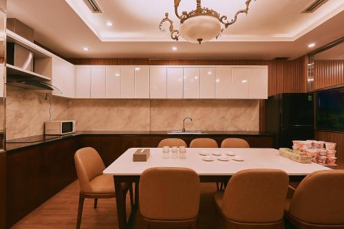 a dining room with a white table and chairs at Mercury Boutique Hotel in Da Nang