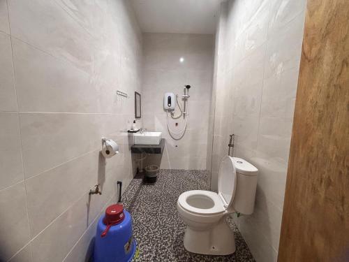 a bathroom with a toilet and a shower in it at Kundasang Guesthouse in Kundasang