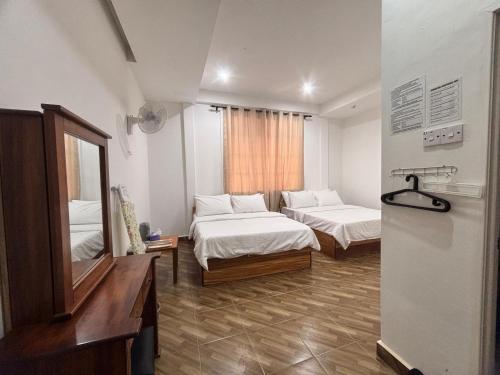 a hotel room with two beds and a mirror at Kundasang Guesthouse in Kundasang