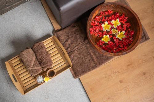 a bowl of flowers on the floor next to a table at Abasan Hill Hotel and Spa in Nusa Penida