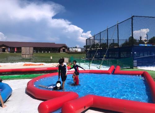 deux enfants jouent dans une piscine gonflable dans l'établissement Makino MegRia, à Takashima