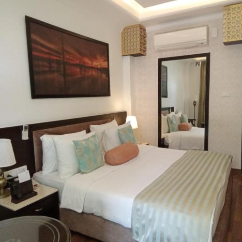 a bedroom with a large white bed and a mirror at Fortune Park Moksha, Mcleodganj - Member ITC Hotels' Group in McLeod Ganj
