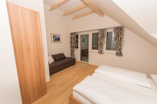 a bedroom with a bed and a couch in a room at Apartment Angerer Bad Aussee in Bad Aussee