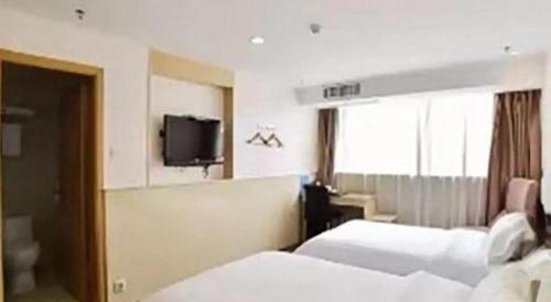 a hotel room with two beds and a tv at Super 8 Hotel Xiamen Railway Station in Xiamen