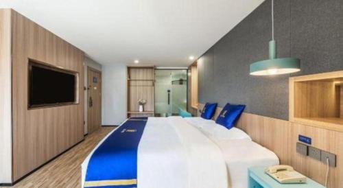 a large bedroom with a large bed and a tv at Super 8 Hotel Xiamen Railway Station in Xiamen