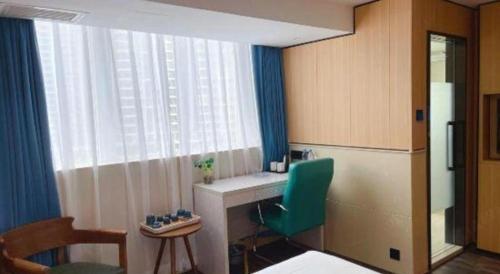 a room with a desk and a green chair at Super 8 Hotel Xiamen Railway Station in Xiamen