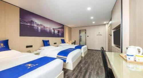 a hotel room with two beds and a television at Super 8 Hotel Xiamen Railway Station in Xiamen