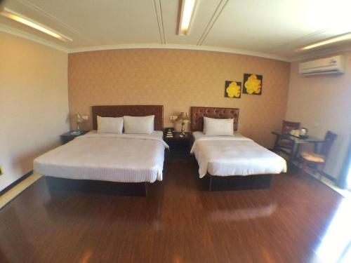 two beds in a room with wooden floors at Grand Hoyah Hotel in Olongapo