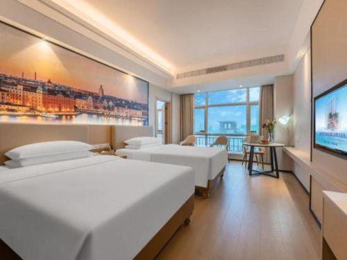a hotel room with two beds and a flat screen tv at Exchange Bank Hotel Hainan in Haikou