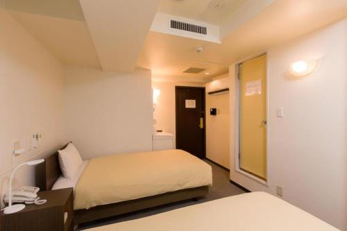 a hotel room with two beds and a bathroom at Ikebukuro Royal Hotel Higashiguchi in Tokyo