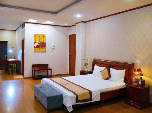 a bedroom with a large bed with a wooden headboard at Gia Bao Hotel Bac Ninh in Hanoi