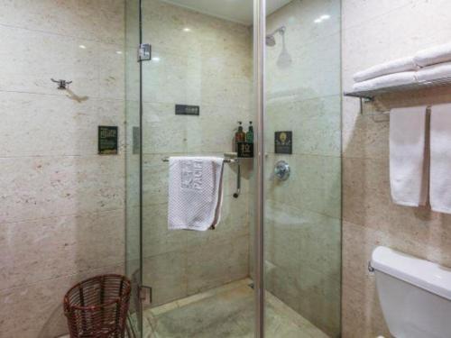 a bathroom with a shower with a glass door at Jincheng Pacific Hotel in Jincheng
