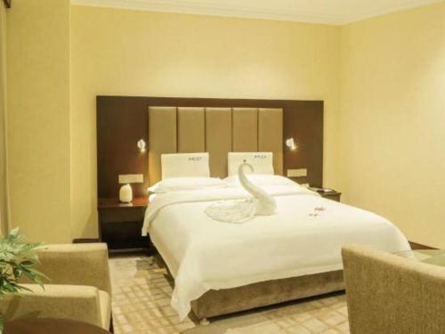 a hotel room with a large bed with a swan on it at Jincheng Pacific Hotel in Jincheng
