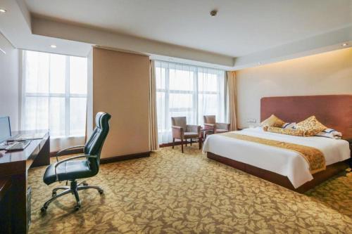 a hotel room with a bed and a desk at Jincheng Pacific Hotel in Jincheng