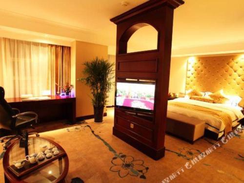 a bedroom with a bed and a tv in a room at Jincheng Pacific Hotel in Jincheng