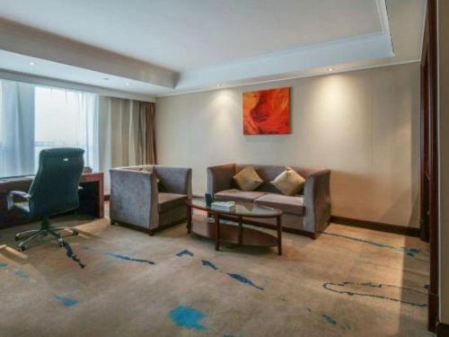a living room with a couch and a chair at Jincheng Pacific Hotel in Jincheng